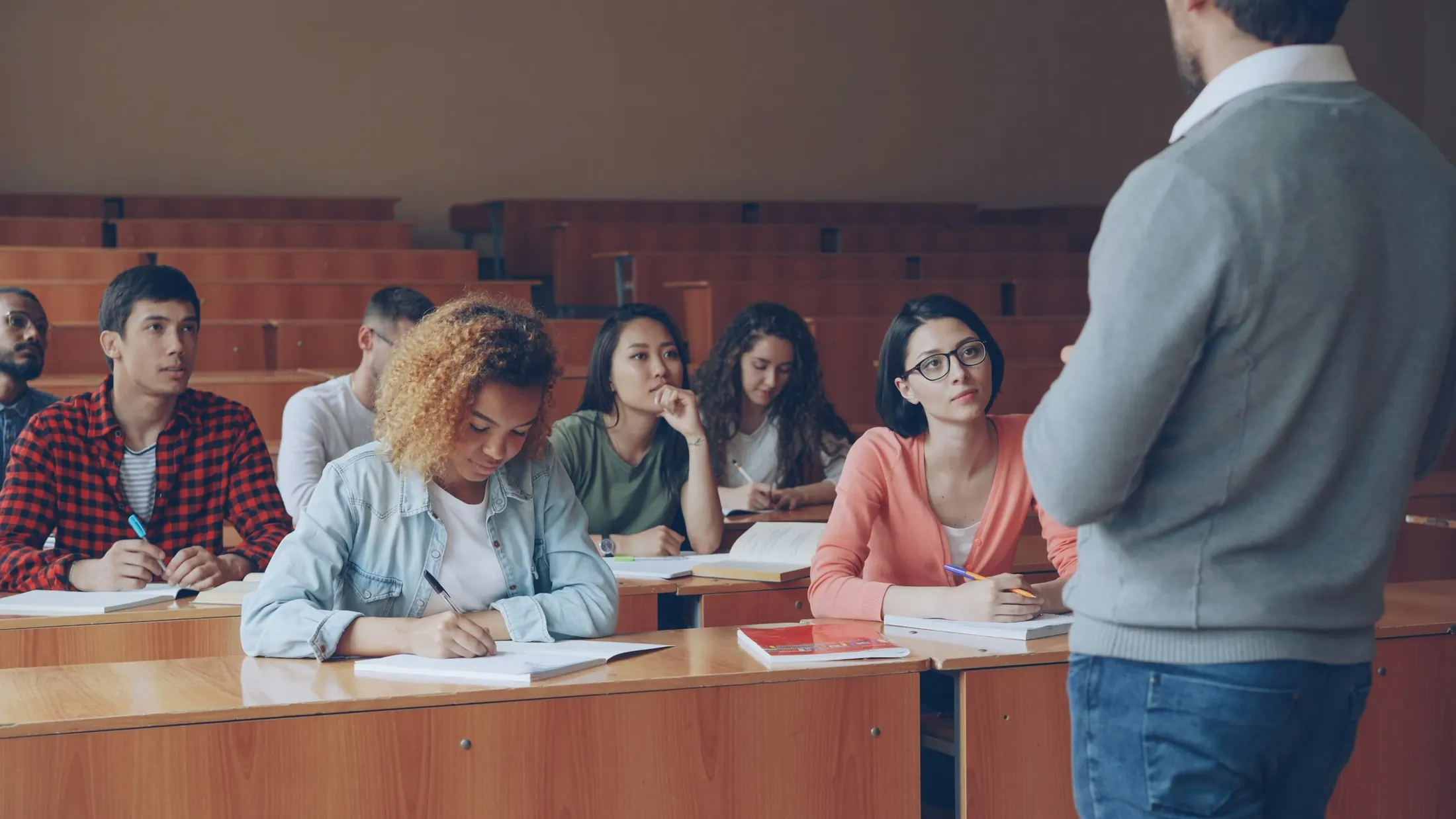 Estudiantes atendiendo a una clase en un aula universitaria